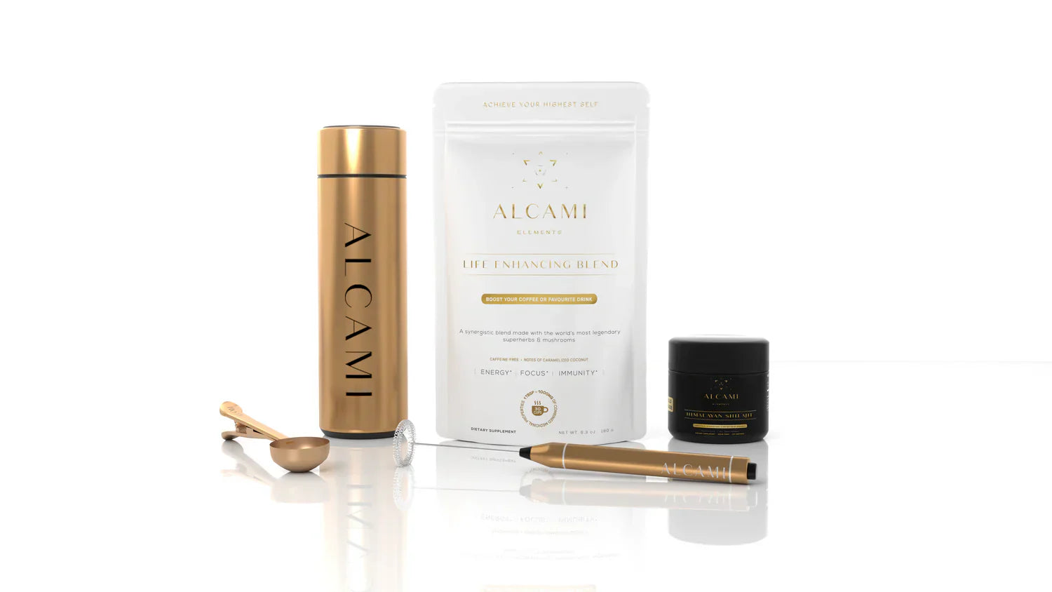 An assortment of Alcami Elements’ products like a gold thermos, a glass tumbler, a small spoon, and a black jar of Himalayan Shilajit.