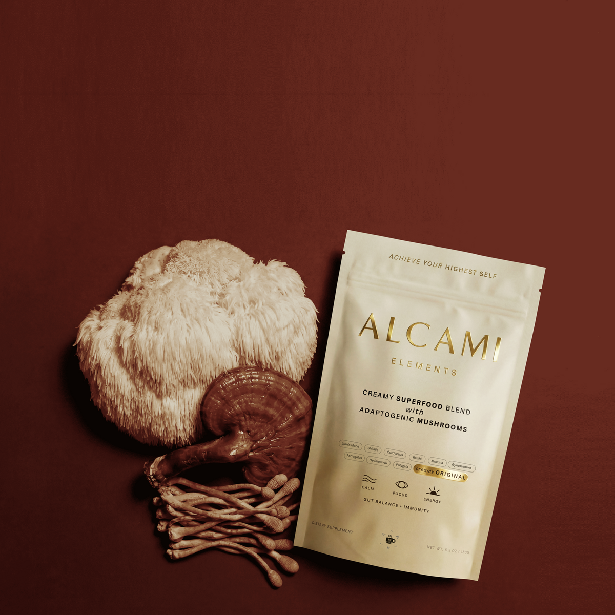 Alcami Elements pouch beside lion's mane and reishi mushrooms on a deep red background