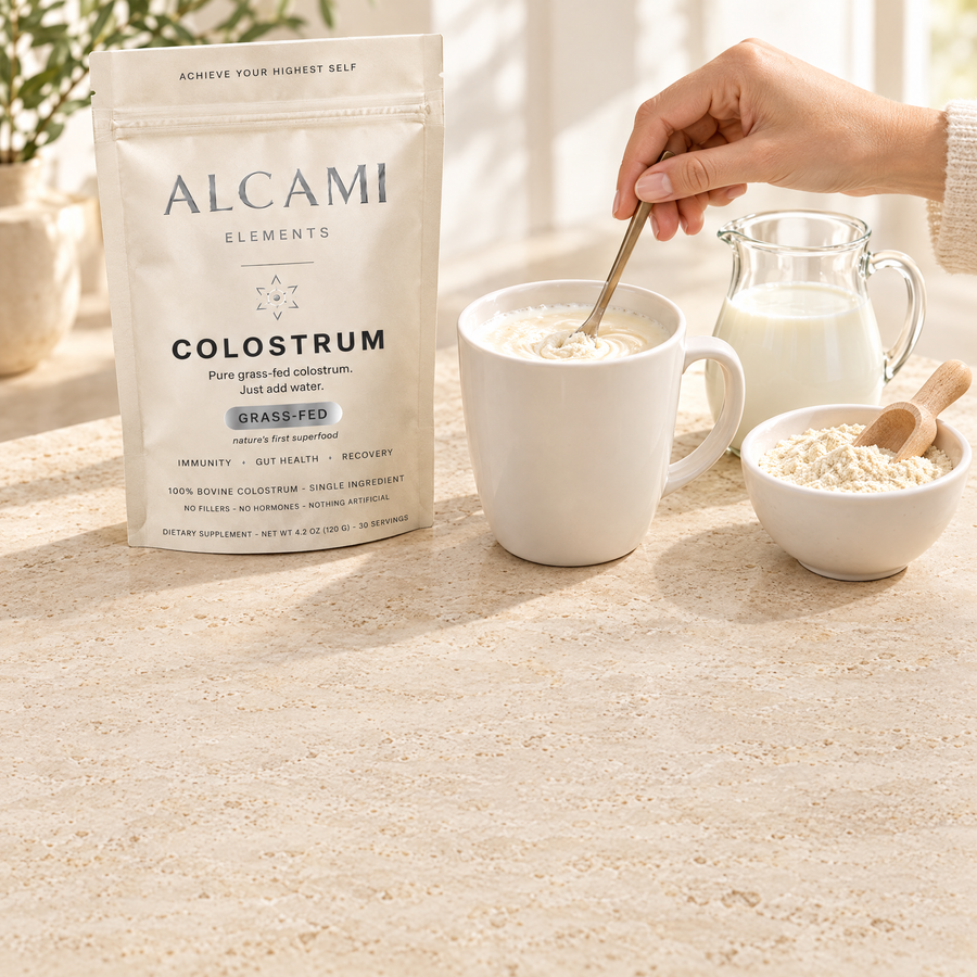 Colostrum powder being stirred smooth into a splash of milk in a mug