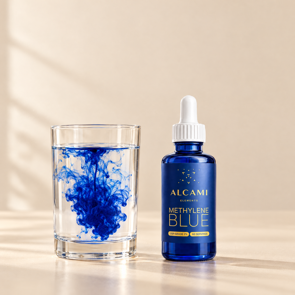 Alcami Methylene Blue bottle beside a glass of water with blue dye blooming through it